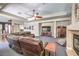 Spacious living room featuring a fireplace, fan, and a comfortable leather couch at 8516 Canyon Ranch St, Las Vegas, NV 89131