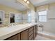 Bathroom featuring a double vanity, decorative mirror and tiled shower at 8608 Willow Cabin St, Las Vegas, NV 89131