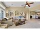 Spacious living room with a large sectional sofa, ceiling fan, and views to the backyard at 8608 Willow Cabin St, Las Vegas, NV 89131