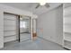 Carpeted bedroom with ceiling fan, mirrored closet, and built in shelves at 8761 Anchor Point Ave, Las Vegas, NV 89117