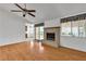 Spacious living room featuring hardwood floors, ceiling fan, and brick fireplace at 8761 Anchor Point Ave, Las Vegas, NV 89117