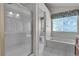Well-lit bathroom featuring a shower, bathtub, a vanity and window overlooking the garden at 8761 Anchor Point Ave, Las Vegas, NV 89117