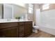 Bathroom featuring double sinks with wood cabinets, a large mirror, and a shower with a tub at 8873 Howell St, Las Vegas, NV 89166