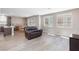 Bright living area with wood-look floors, a comfortable leather couch, and ample windows at 8873 Howell St, Las Vegas, NV 89166