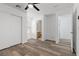 Bright bedroom featuring wood-look floors, a ceiling fan, and multiple entryways at 9174 Mcginnis Ave, Las Vegas, NV 89148