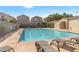 Inviting community pool area with clear blue water, chaise lounges for relaxation, and nearby residential buildings at 9174 Mcginnis Ave, Las Vegas, NV 89148