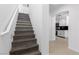 Hallway with wooden stairs leading to the upper level and a view of the kitchen at 9174 Mcginnis Ave, Las Vegas, NV 89148