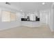 Open-concept living space with neutral tile flooring, natural light, and kitchen access at 9174 Mcginnis Ave, Las Vegas, NV 89148