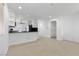 Open-concept living space with neutral tile flooring, natural light, and kitchen access at 9174 Mcginnis Ave, Las Vegas, NV 89148