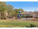 Community playground area with play structures, mature trees, a lawn, and nearby seating areas at 9174 Mcginnis Ave, Las Vegas, NV 89148