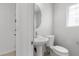 Clean powder room features a pedestal sink, toilet, mirror and a window that provides natural light at 9174 Mcginnis Ave, Las Vegas, NV 89148