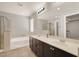 Well-lit bathroom with double sinks, soaking tub, and separate glass shower at 992 Wagner Valley St, Henderson, NV 89052