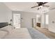 Bright bedroom with neutral walls, ceiling fan and view to the hallway and bathroom at 992 Wagner Valley St, Henderson, NV 89052