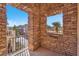Balcony view through stone arches featuring palm trees and neighborhood homes at 1 Corte Belleza, Henderson, NV 89011