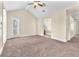 Bright main bedroom featuring carpeted floors, ceiling fan, and access to bathroom and walk in closet at 1 Corte Belleza, Henderson, NV 89011