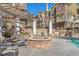 Resort-style pool area with a stone fire pit, comfortable seating and views of the surrounding buildings at 1 Corte Belleza, Henderson, NV 89011
