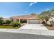 Attractive single-story home with a red tile roof, green lawn, and a wide driveway at 10009 Netherton Dr, Las Vegas, NV 89134