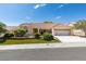 Inviting single-story home featuring a well-manicured front yard, a two-car garage, and a classic red tile roof at 10009 Netherton Dr, Las Vegas, NV 89134