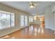 Open-concept living room with hardwood floors, a ceiling fan, and natural light from the windows and glass doors at 10009 Netherton Dr, Las Vegas, NV 89134