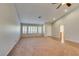 Bright living room with carpet, plantation shutters, and doorway leading to an adjoining bathroom at 10009 Netherton Dr, Las Vegas, NV 89134