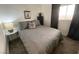 Modern bedroom with gray bedding, a window with dark curtains, and minimalist decor at 1018 Snow Bunting Ct, Henderson, NV 89002