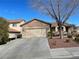 View of the home featuring a two car garage, desert landscaping and a covered porch with patio furniture at 1018 Snow Bunting Ct, Henderson, NV 89002