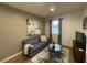 Cozy living room featuring a comfortable gray couch, rug, and modern artwork at 1018 Snow Bunting Ct, Henderson, NV 89002