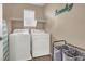 Functional laundry room with white appliances, shelving, and a convenient storage rack at 10230 Danskin Dr, Las Vegas, NV 89166