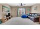 Comfortable living room featuring neutral paint, carpet flooring, and a plush sofa with a blue ottoman at 10230 Danskin Dr, Las Vegas, NV 89166