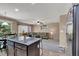 Open-concept living space with a kitchen island, comfortable seating, and sliding door access to a patio at 10230 Danskin Dr, Las Vegas, NV 89166