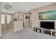 Cozy loft space with neutral carpet, TV, and a view into another living area at 10230 Danskin Dr, Las Vegas, NV 89166