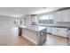 Bright open kitchen with white cabinets, island with stone countertop, and wood floors at 10433 Smokey Mariposa Ave, Las Vegas, NV 89166