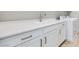 Bright laundry room with white cabinets, quartz countertops and a stainless steel faucet at 10433 Smokey Mariposa Ave, Las Vegas, NV 89166