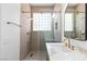 Modern bathroom featuring a walk-in shower with glass enclosure and gold fixtures, and a marble countertop sink at 10540 Beachwalk Pl, Las Vegas, NV 89144