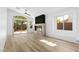 Bright living room with fireplace feature wall, wood-look floors, and sliding glass door to backyard at 10540 Beachwalk Pl, Las Vegas, NV 89144