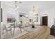 Bright living and dining area with contemporary furnishings, light wood floors, and modern light fixtures at 10540 Beachwalk Pl, Las Vegas, NV 89144