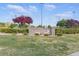 Scenic view of The Crossing Park entrance with lush greenery and a stone sign at 10540 Beachwalk Pl, Las Vegas, NV 89144