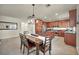 Open-concept kitchen with stainless steel appliances, wood cabinets, and an adjacent dining area at 11908 Menchaca Ln, Las Vegas, NV 89138