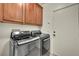 Modern laundry room with front-loading washer and dryer set and convenient overhead cabinets at 11908 Menchaca Ln, Las Vegas, NV 89138