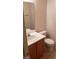 Bathroom with white sink, wooden cabinets, and toilet at 1236 Dusty Creek St, Las Vegas, NV 89128