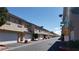 Exterior view of condo building units with private garages, lush landscaping and street signage at 1236 Dusty Creek St, Las Vegas, NV 89128