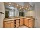 Bathroom with dual sinks, granite counters, a large mirror and natural wood cabinets at 12780 Davis Wright Ct, Henderson, NV 89044