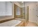 Bathroom with a glass shower, luxurious tub, and window for natural light at 12780 Davis Wright Ct, Henderson, NV 89044