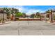 View of community gate at entry with mature trees, beautiful landscaping, and lamp posts at 12780 Davis Wright Ct, Henderson, NV 89044
