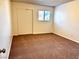 Neutral bedroom featuring carpet flooring, closet with sliding doors, and a bright window at 1316 Capri Dr # Abc&D, Boulder City, NV 89005