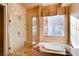 Spacious bathroom with tiled walk-in shower, soaking tub, and large window at 15 Via Mantova # 401, Henderson, NV 89011