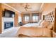 Relaxing primary bedroom features a cozy fireplace, a sitting area, and large windows at 15 Via Mantova # 401, Henderson, NV 89011