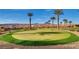 View of the backyard putting green with palm trees and mountain views; a golfer's paradise! at 15 Via Mantova # 401, Henderson, NV 89011