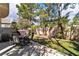Outdoor living space with hot tub, seating area, lush artificial grass, and privacy landscaping at 1825 Derbyshire Dr, Las Vegas, NV 89117