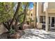 Backyard featuring a patio with dining set, artificial grass, mature landscaping, and elegant design at 1825 Derbyshire Dr, Las Vegas, NV 89117